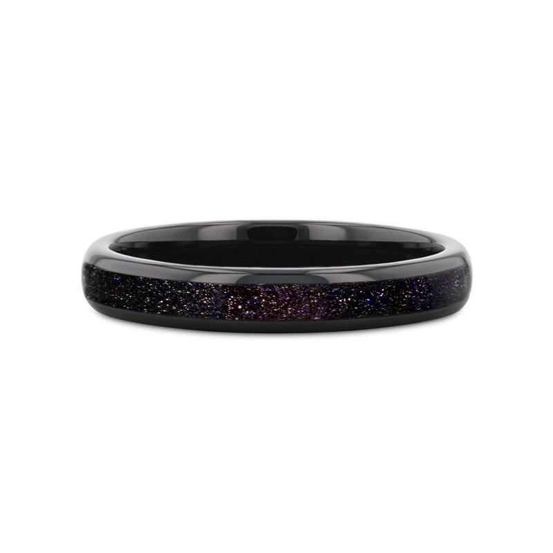 Black ring with speckled pattern on a white background